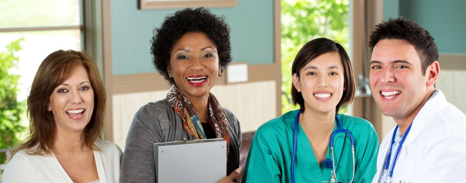 Diverse chiropractic assistant team and doctor smiling together in a clinic setting