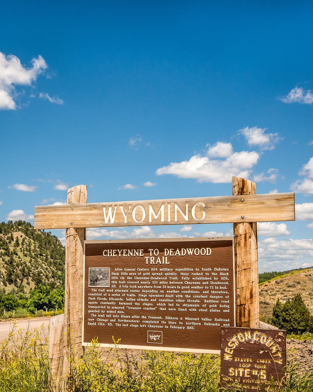 Wooden Wyoming welcome sign at the Cheyenne-to-Deadwood Trail marker under a blue prairie sky — Wyoming 4-hour online maximum chiropractic CE bundle, Board of Chiropractic Examiners online cap, CCEDseminars