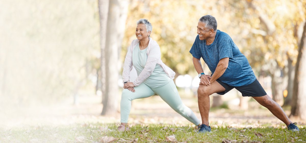 Active seniors stretching in the park during chiropractic geriatrics program for strength, balance, and mobility
