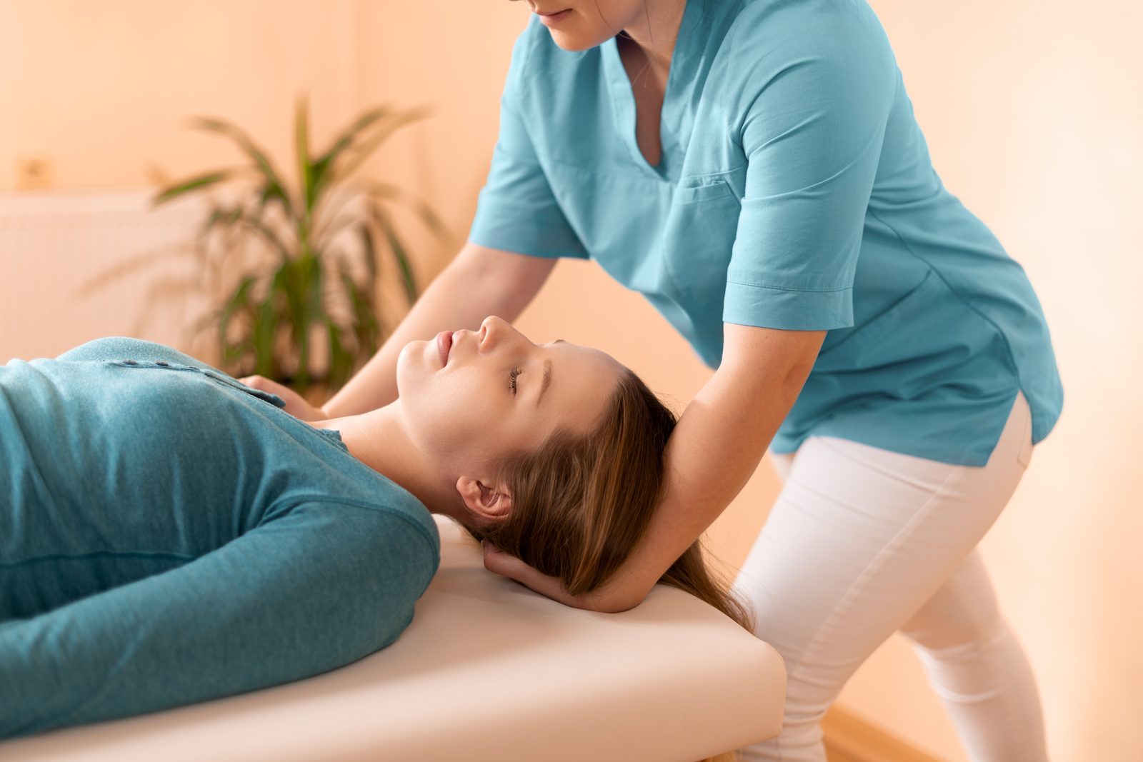 Clinician cradling the head of a supine patient during an upper cervical spine assessment — Adjusting & Manual Therapy 208: Cervical Spine & TMJ online chiropractic CE course