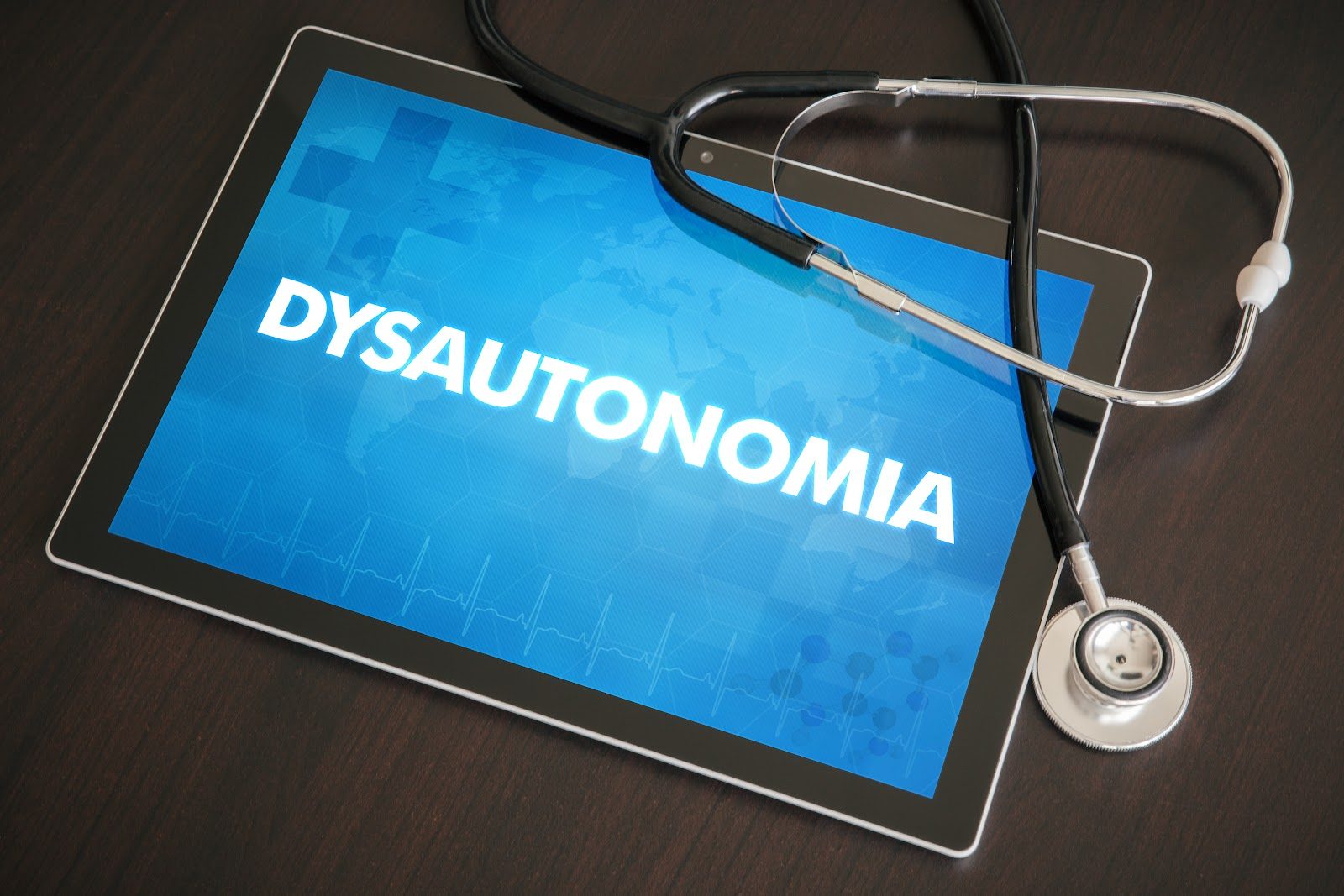Tablet screen displaying the word dysautonomia in a medical interface, with a stethoscope resting on the desk beside it