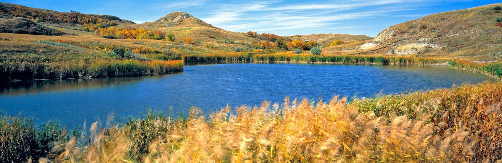 North Dakota prairie lake with rolling hills and autumn grasses — hero for North Dakota chiropractic CE requirements (20 hours annually; renewal September 1)