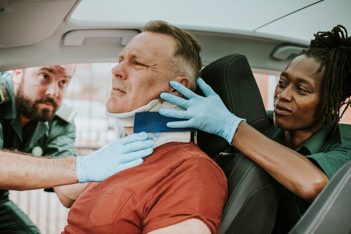 Paramedics fitting a cervical collar to an injured driver at a motor vehicle collision — Chiropractic Personal Injury Specialist (CPIS) certification program, CCEDseminars