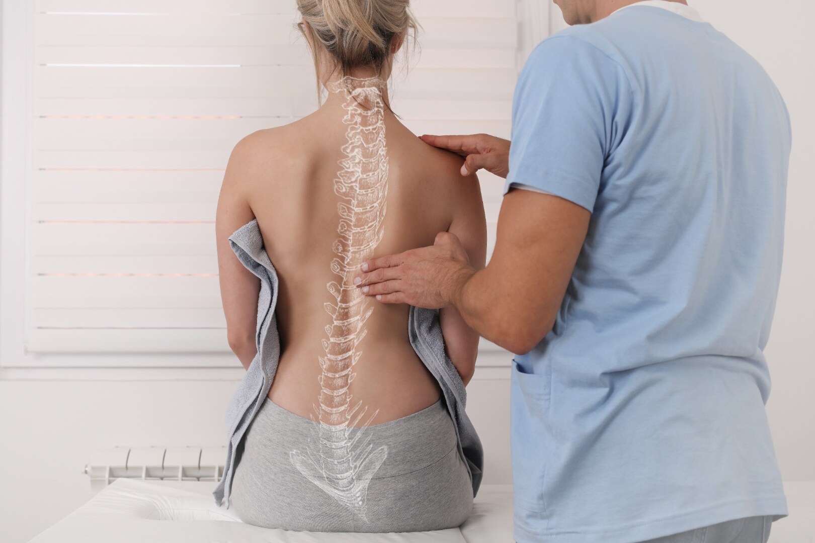 Chiropractor evaluating a patient's spine in a clinical setting