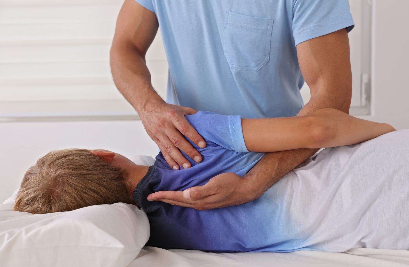 Chiropractor mobilizing the thoracic spine and shoulder blade of a side-lying patient — Adjusting & Manual Therapy 207: Thoracic Spine & Rib Cage online chiropractic CE course