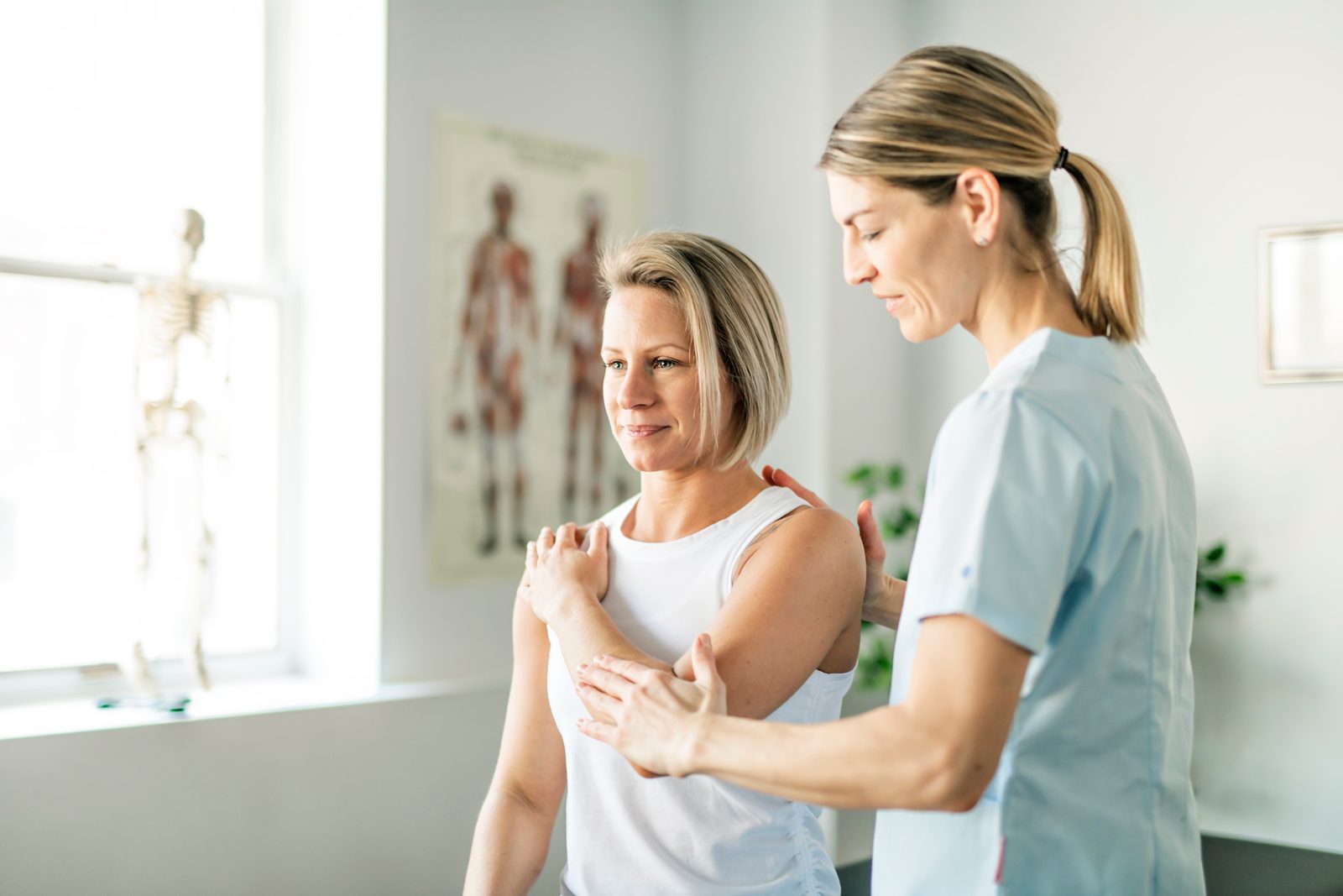 Clinician guiding a seated patient through a partner assisted cross-body shoulder stretch — Adjusting & Manual Therapy 211: Partner Assisted Stretching online chiropractic CE course