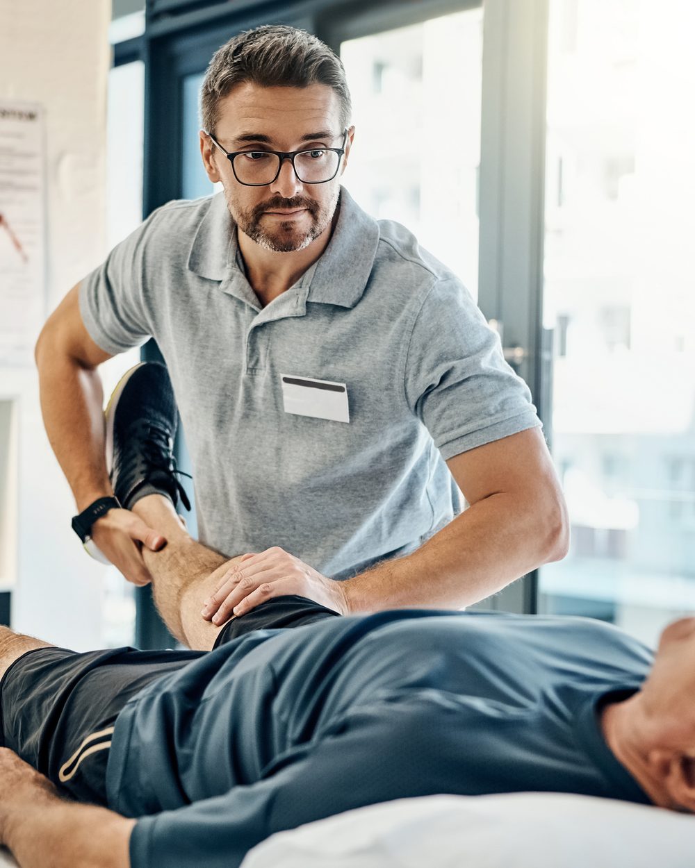Clinician performing a lower extremity physical examination on a patient — on-demand chiropractic physical examination CE; CCEDseminars category page