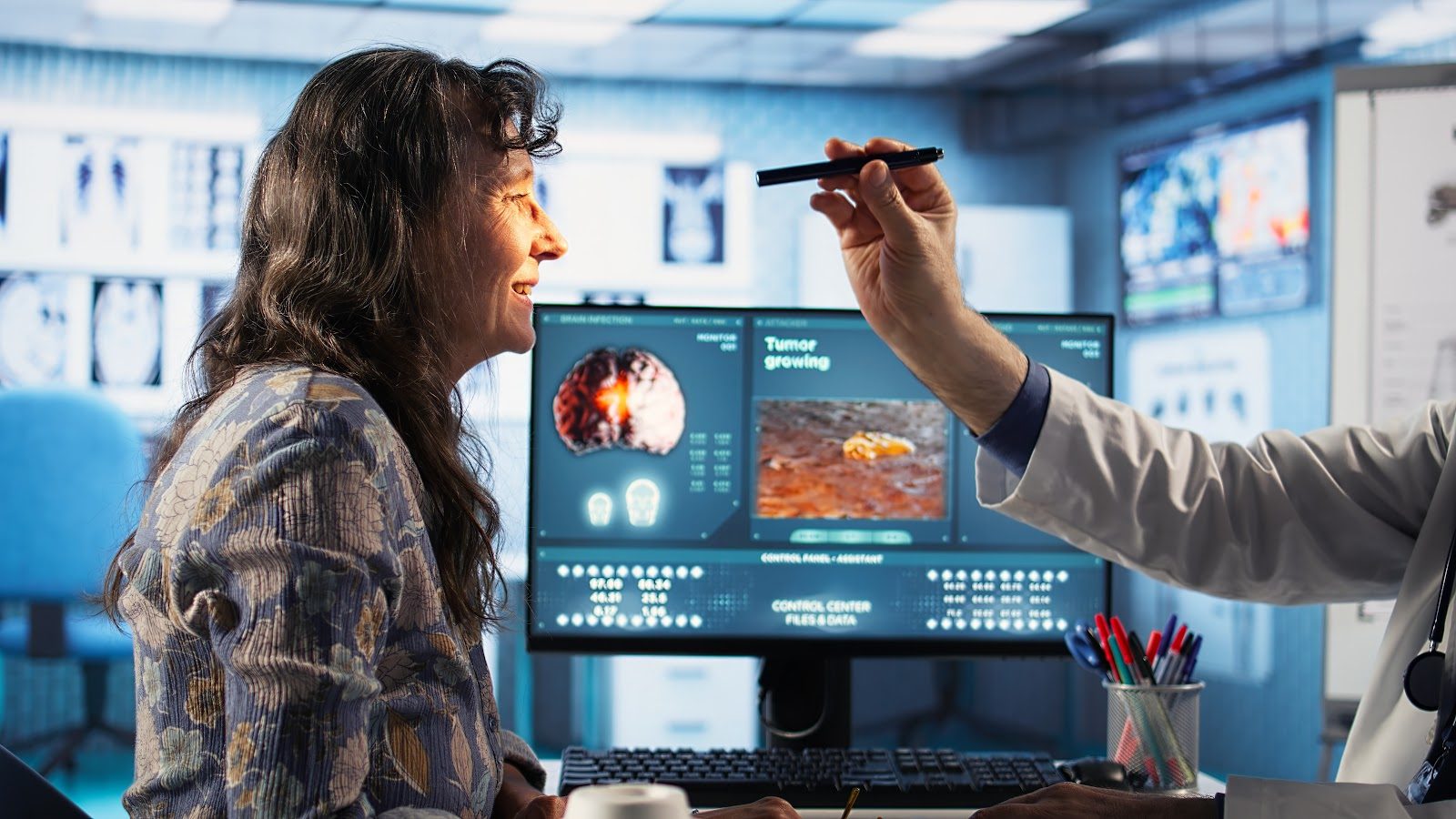 A clinician pointing with a pen at brain-scan images on a wall of monitors while a colleague looks on — the concussion assessment and omega-3-based nutritional management that Nutrition 240 teaches chiropractors for the clinical setting