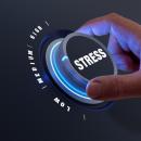 Hand turning a dial labeled Stress down from high toward low against a dark blue background