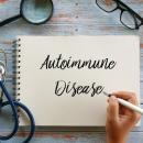 Notebook page with the words Autoimmune Disease handwritten beside a stethoscope, magnifying glass, glasses and a pen on a wooden desk